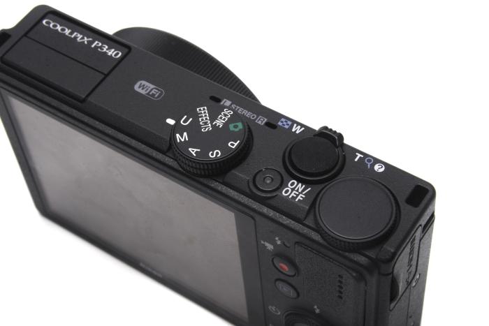 The top view shows the concealed flash on the left, the mode dial, and the dial that can be used to change shutter speed in manual mode.